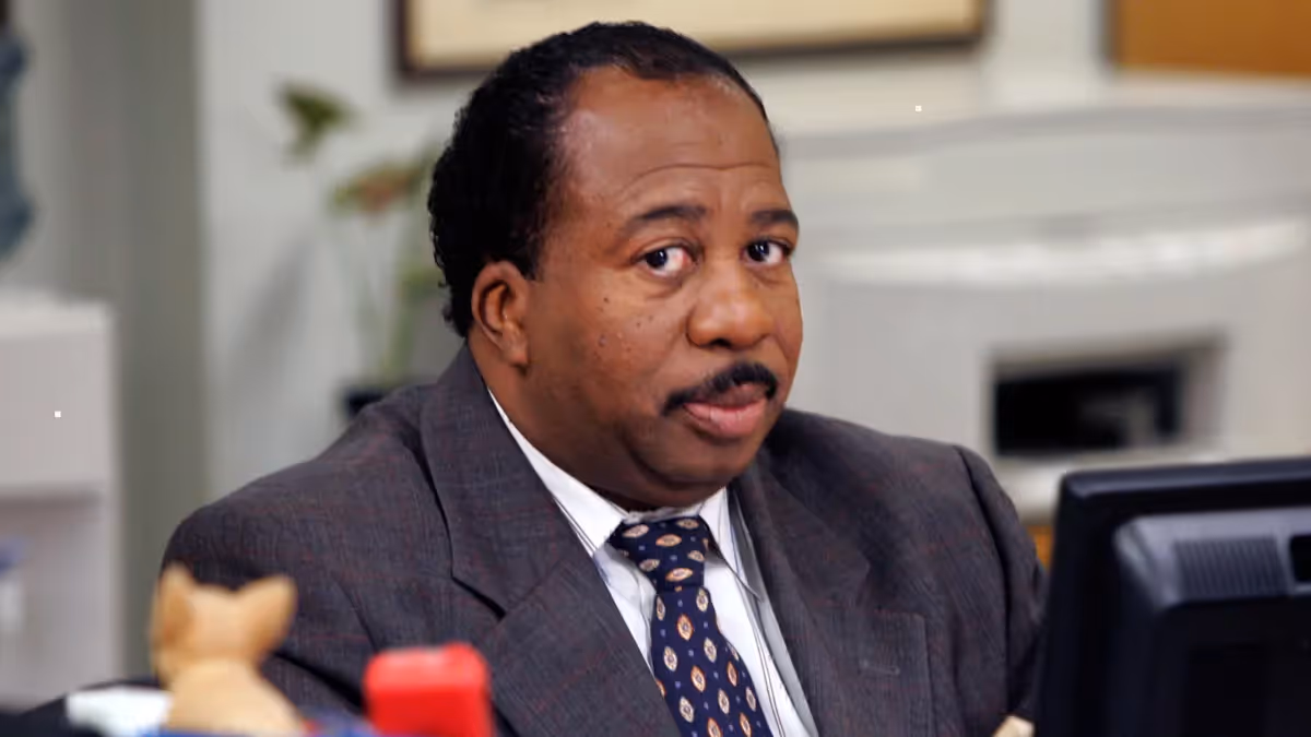 Stanley Hudson from The Office sitting at his desk with a disinterested expression | Timestripe