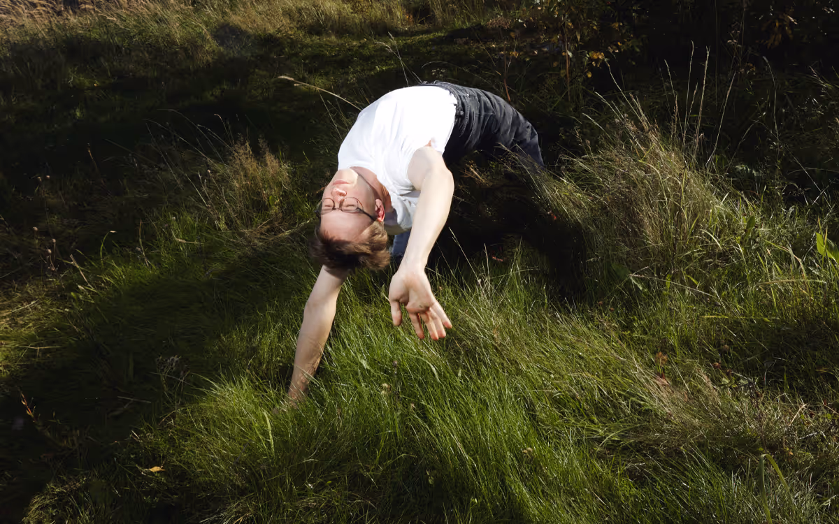 guy in a forest in a peculiar pose